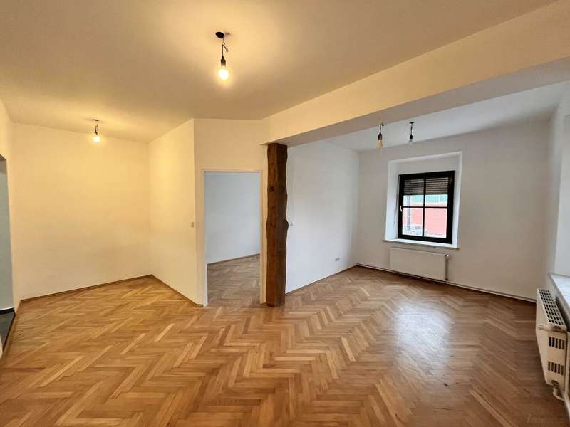 Wohnzimmer mit Essbereich und Zugang ins Schlafzimmer